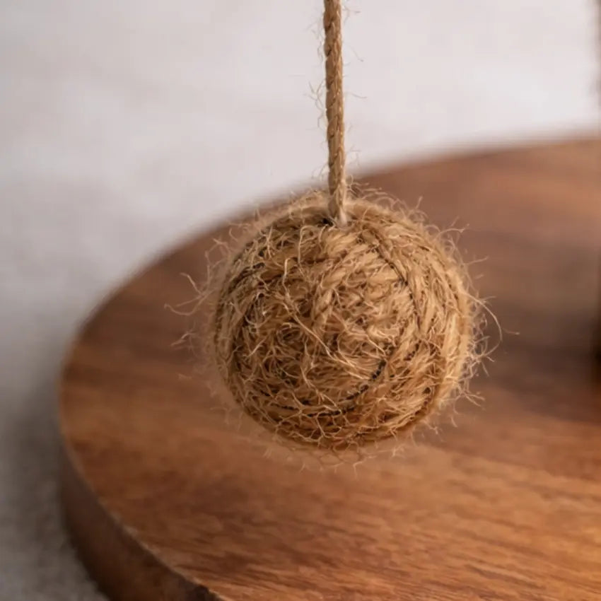 Detalhe da bola suspensa em fibra de coco e da base em madeira da árvore para gatos Cafeeiro Panier