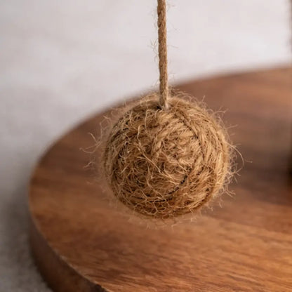 Detalhe da bola suspensa em fibra de coco e da base em madeira da árvore para gatos Cafeeiro Panier